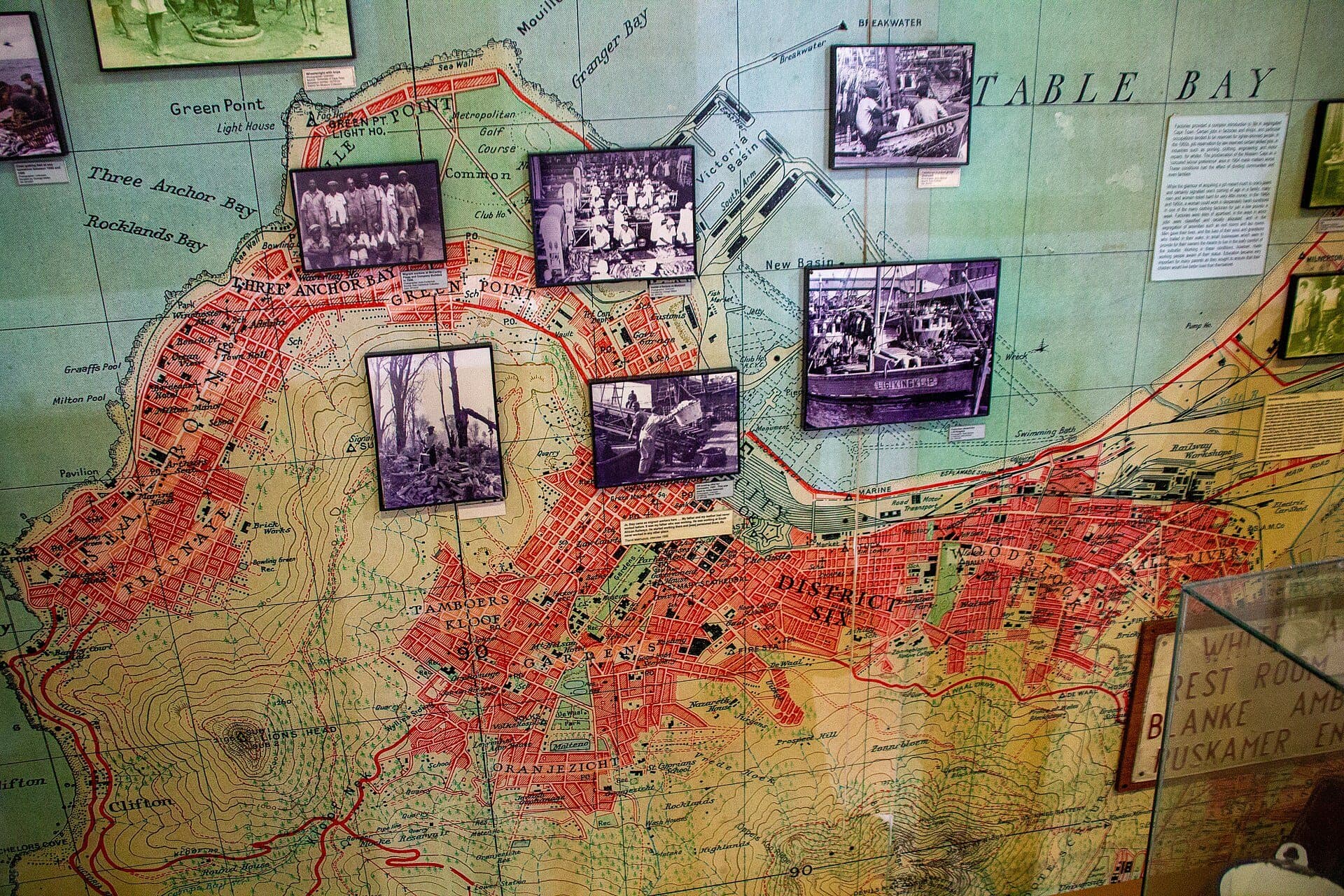 A map of District Six hung with photographs of its streets and families, in the District Six Museum
